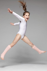 Young excited girl jumping in the studio