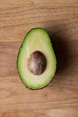Half and avocado on wooden chopping board