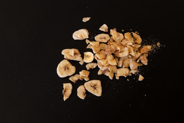 Dried banana scattered on a black background