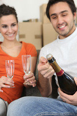 couple opening bottle of champagne