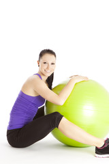 Fototapeta na wymiar Lachende sportliche Frau mit Gymnastikball