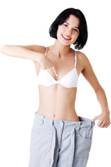 Fototapeta premium Woman showing how much weight did she lost.