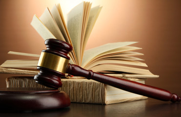 wooden gavel and books on wooden table,on brown background