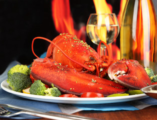 Red lobster on platter on wooden table on fire background