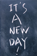 it is a new day title written with chalk on blackboard