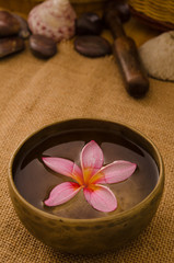 Obraz na płótnie Canvas tropical spa setup with traditional frangipani flower and massag
