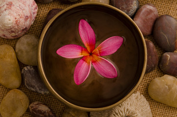 Obraz na płótnie Canvas tropical spa setup with traditional frangipani flower and massag