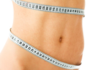 A young woman measuring her waist
