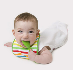 Baby with spoon in mouth looking at camera