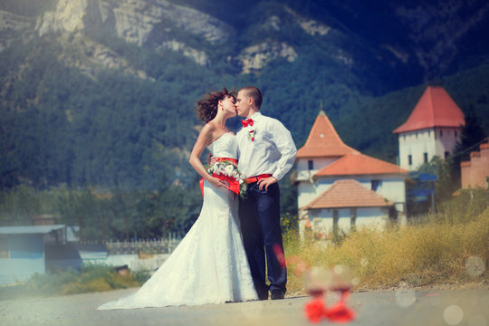 Bride and groom kissing on the background of mountains