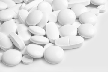 White pills and tablets on white background