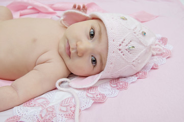 Cute little baby in an amusing pink hat