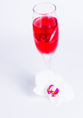 glass with red wine and an orchid