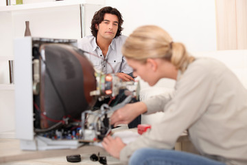 Woman repairing a television set