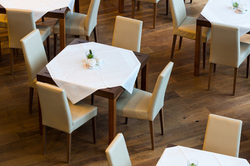 laid table with cloth and leather chairs on wooden floor