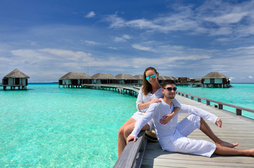 Obraz premium Couple on a beach jetty at Maldives