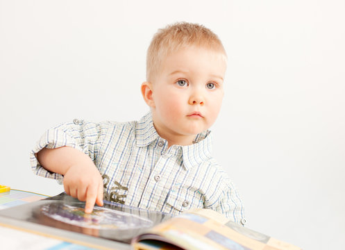 curious baby boy studying wiht the boock