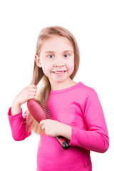 Beautiful little girl brushing her long  hair.