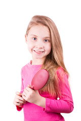 Beautiful little girl brushing her long  hair.