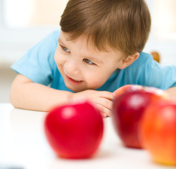 Fototapeta na wymiar Portrait of a happy little boy with apples