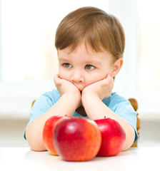 Fototapeta na wymiar Portrait of a sad little boy with apples