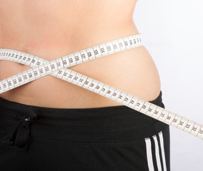 woman measuring her waist with tape measure