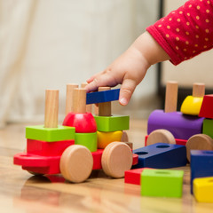 Baby's hand playing with wooden toys - 51120686