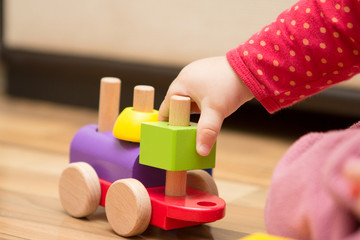 Baby's hand playing with wooden toy