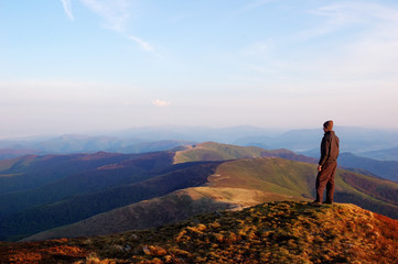 Fototapeta premium Man standing on top of a mountain