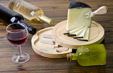 Cheese and wine on wood table.