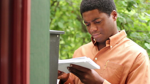 A man checking the mail and finding something positive