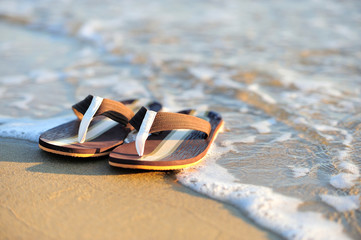 Flip flops on a sandy ocean beach