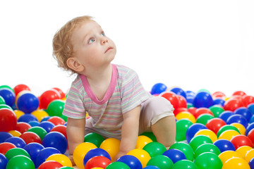 Fototapeta na wymiar Cute kid or child playing colorful balls looking up