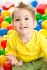 Cute kid or child playing colorful balls top view