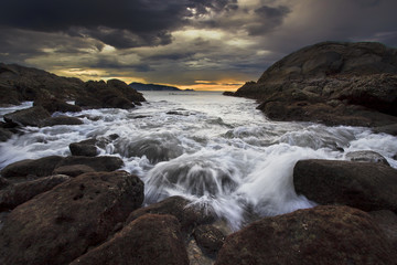 Sea waves lash line impact rock on the beach
