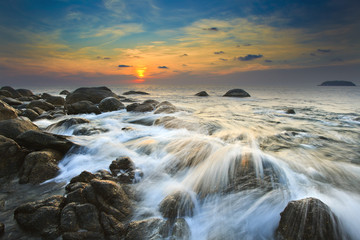 Sea waves lash line impact rock on the beach