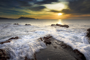 Sea waves lash line impact rock on the beach