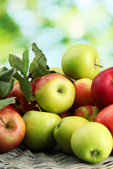 juicy apples with leaves, on green background