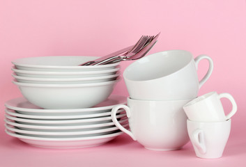 Fototapeta na wymiar Clean white dishes on pink background