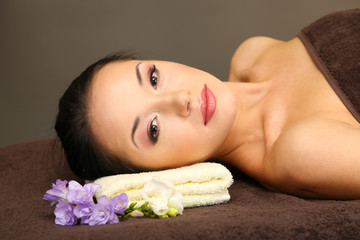 Obraz na płótnie Canvas Beautiful young woman in spa salon, on dark background