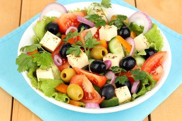 Fresh salad in plate on wooden table