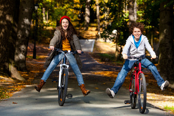 Urban biking - teens riding bikes in city park