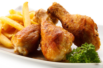 Grilled chicken drumsticks with chips and vegetables