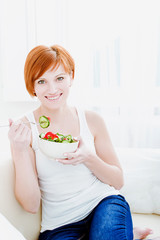 Obraz na płótnie Canvas young happy woman eating salad