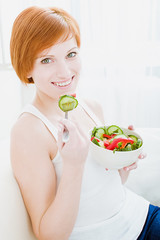 young happy woman eating salad