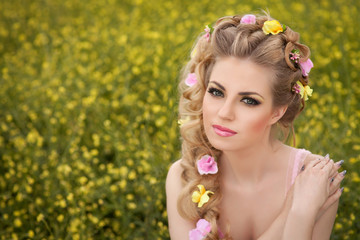 Beautiful blonde woman with hairstyle makeup sring flowers field