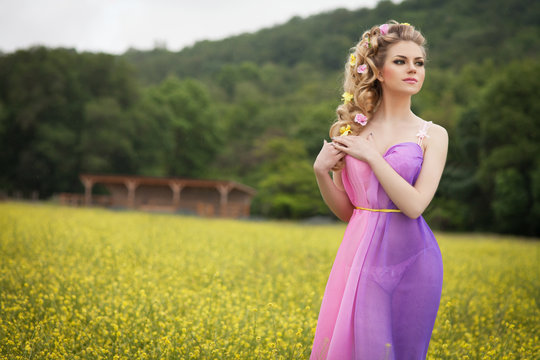 Beautiful blonde woman with hairstyle makeup sring flowers field