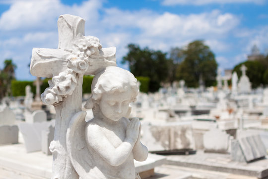 Statue of a praying cherub on a cemetery