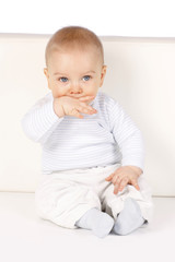 Fototapeta premium süßes Baby sitzt an einer Wand - sweet baby sitting