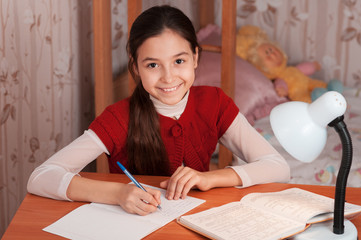 girl doing homework in a notebook